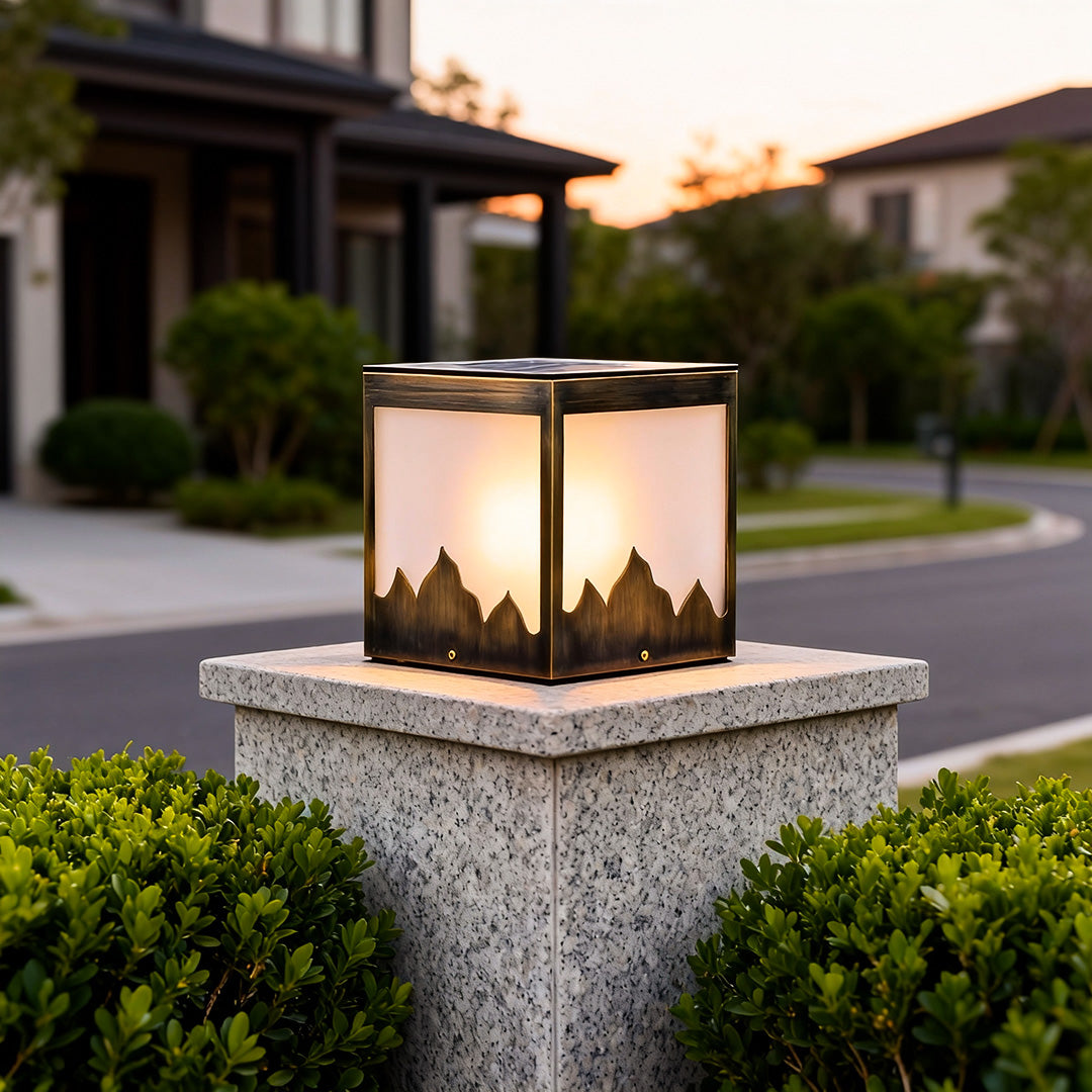 Elegant solar powered pillar lights on a stone pillar, providing warm illumination for a garden entrance.