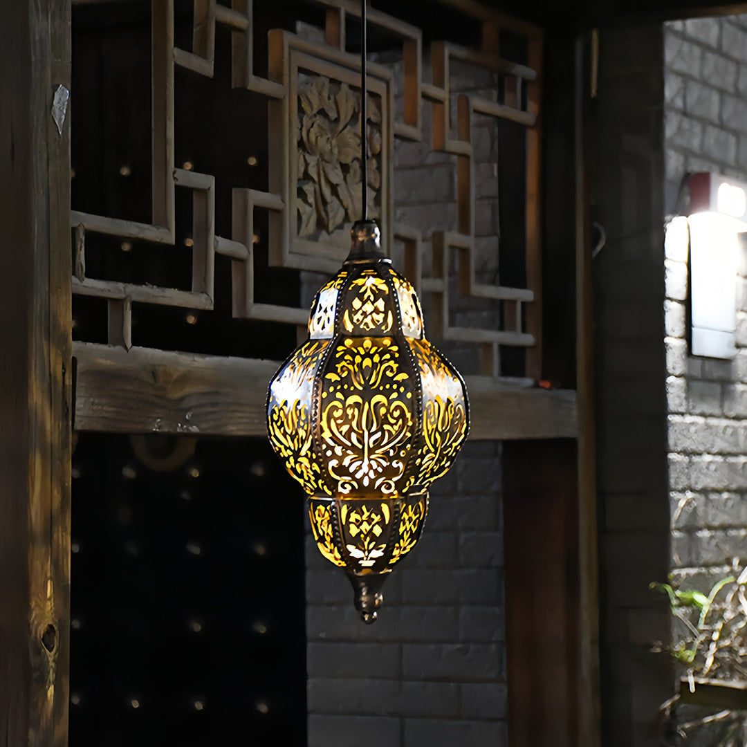 Elegant teardrop outdoor moroccan lanterns casting a warm, intricate pattern against a stone wall at night.