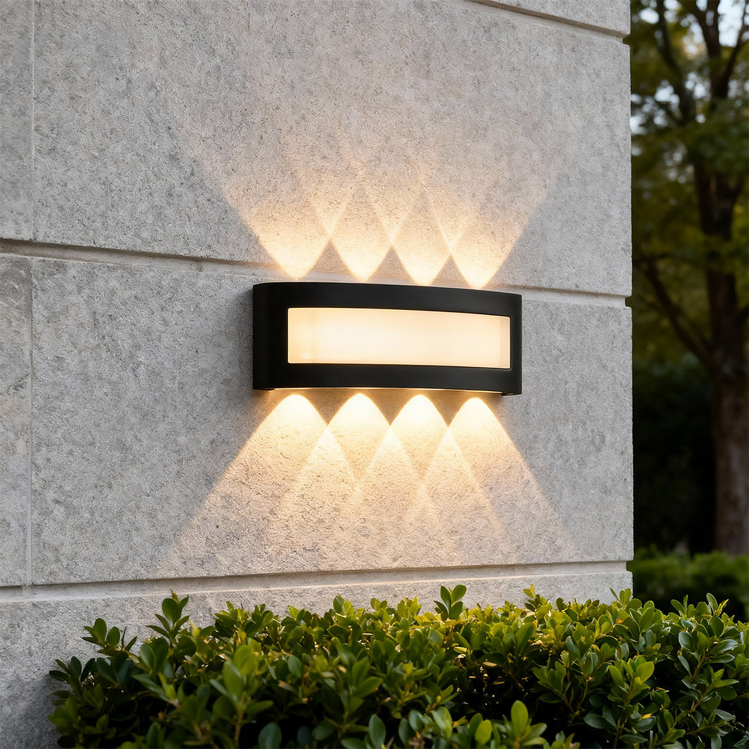 Elegant up down wall lights with glass shade chandelier design illuminating concrete exterior with striking light pattern.