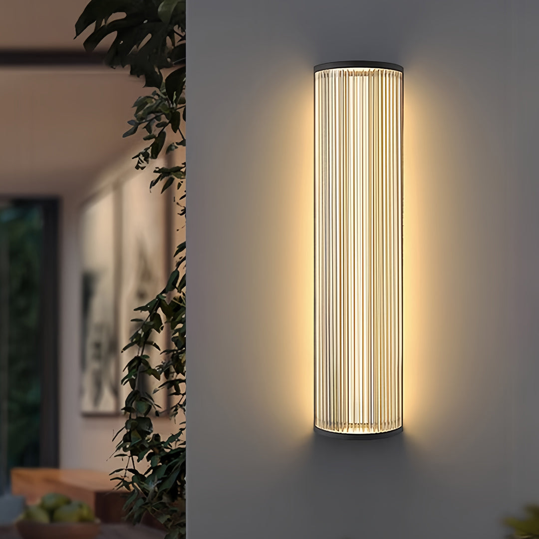 Multiple elegant vertical wall sconce lighting fixtures installed between the windows of a modern building facade.