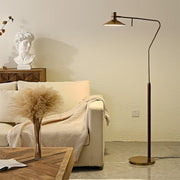 Elegant vintage gold floor lamp in rustic living room setting providing warm ambient lighting beside comfortable seating