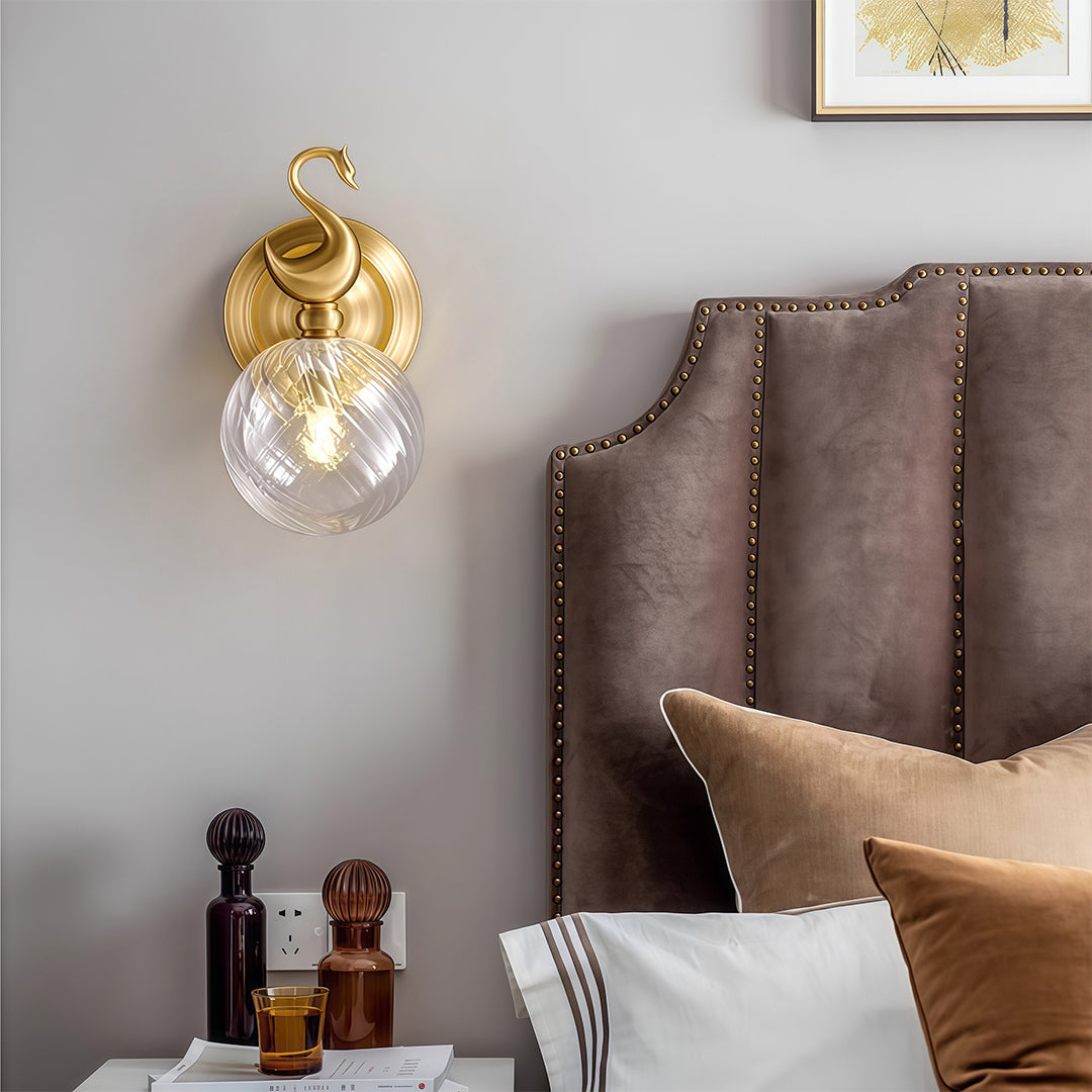 Elegant wall mounted LED light featuring glass shade chandelier design providing ambient lighting above upholstered headboard.