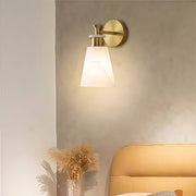 Elegant wall sconce LED light featuring glass shade chandelier design providing ambient lighting beside neutral-toned sofa.