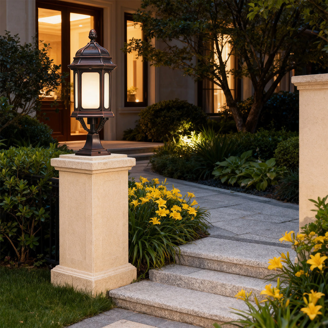 Elegant waterproof outdoor pendant light casting ambient glow on white pillar along curved driveway