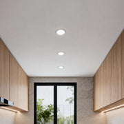 Modern hallway ceiling illuminated with evenly spaced elite lighting can lights for clean ambient lighting.