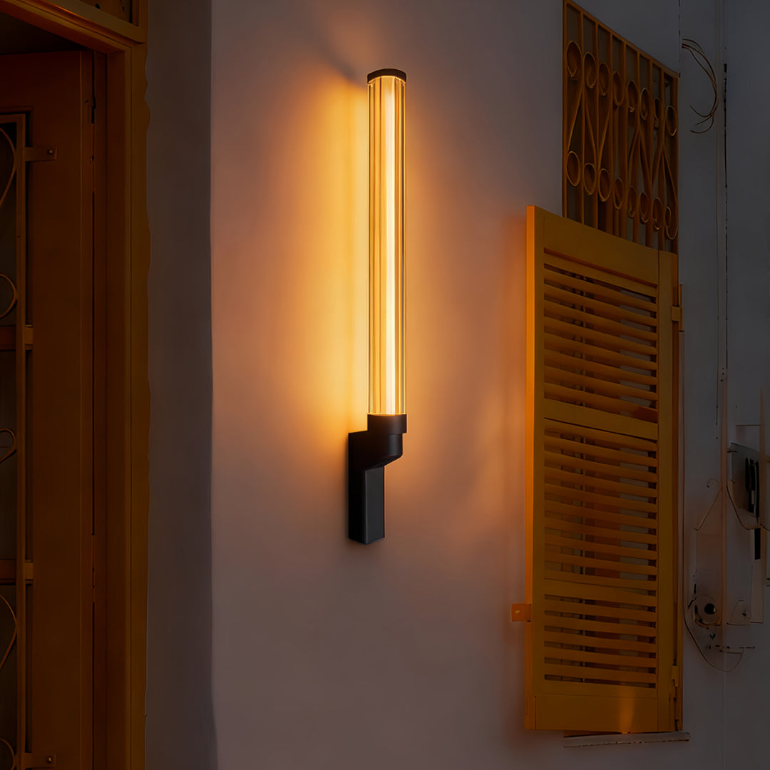 Elongated warm outdoor sconces modern mounted on a textured façade creating an elegant nighttime ambiance.