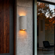 Warm glow from up down wall lights installed beside a contemporary entrance door.