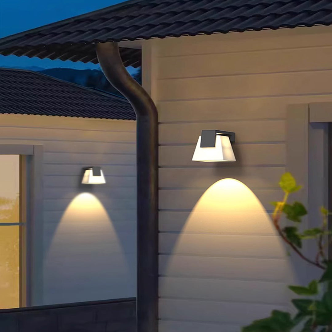 Stylish wall mounted outdoor lights enhancing the entrance of a contemporary home at dusk.