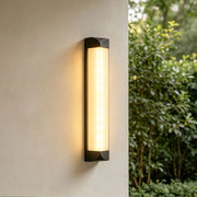 Wall sconce outdoor illuminating a modern building entrance with warm architectural light.
