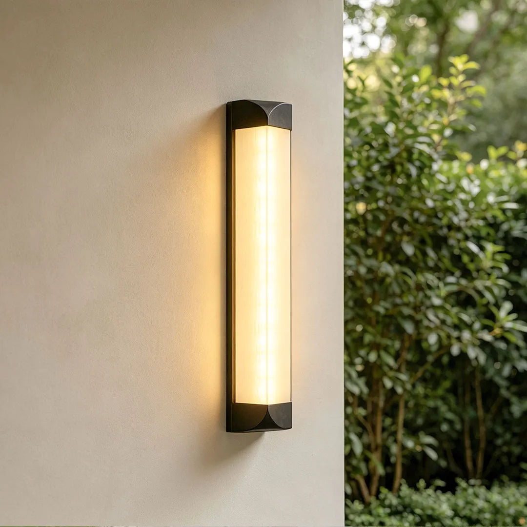 Wall sconce outdoor illuminating a modern building entrance with warm architectural light.