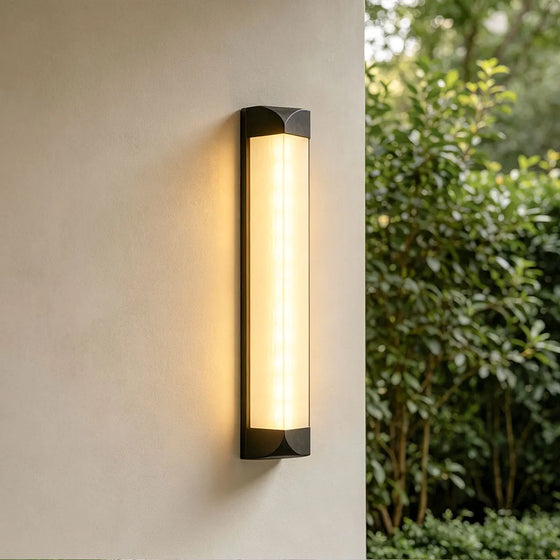 Wall sconce outdoor illuminating a modern building entrance with warm architectural light.