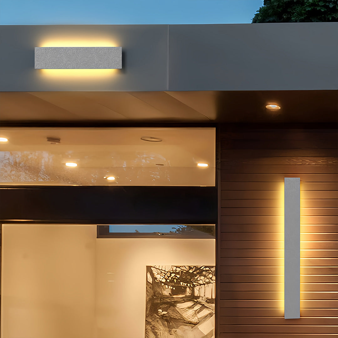Modern outdoor wall sconces illuminating a contemporary entryway with clean geometric lighting design.