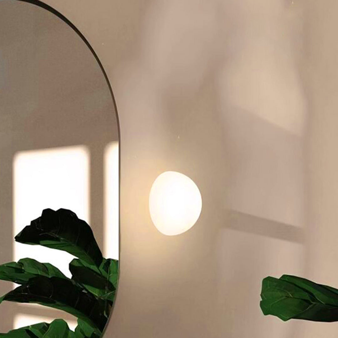 Soft warm outdoor lighting wall mounted lamp installed along a curved entryway wall.