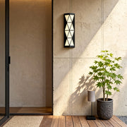Warm outdoor wall sconces lighting fixture mounted near an entryway, adding welcoming illumination to the space.