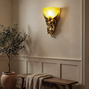 Elegant European angel wall sconce casting a warm glow in a classic living room with neutral decor.