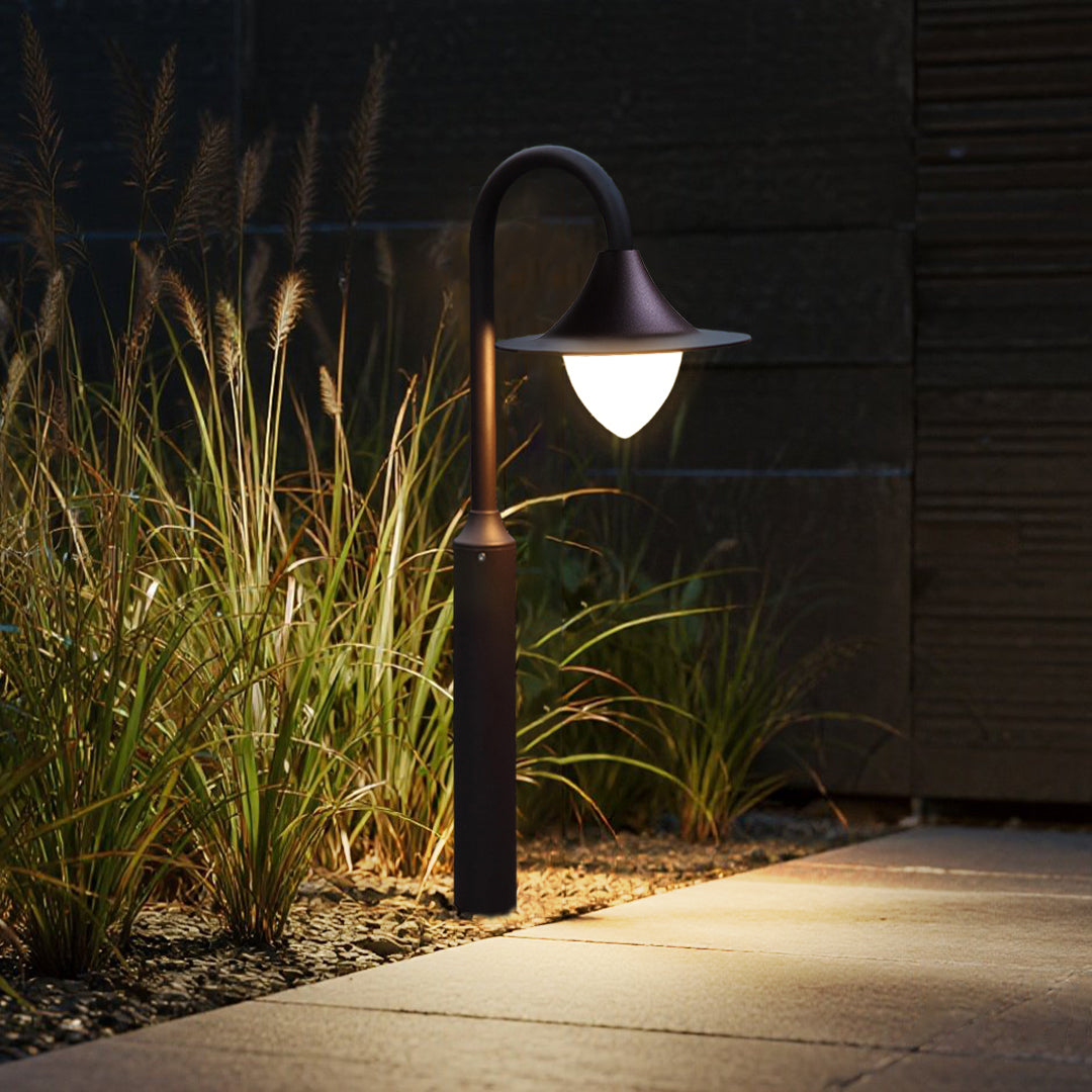 Evening garden pathway illuminated by curved bollard lights creating warm ambient lighting atmosphere