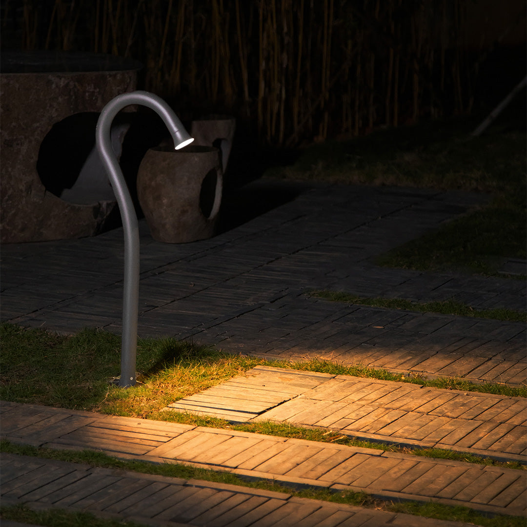 Evening pathway lighting showcasing curved fixtures creating warm ambient glow on walkway