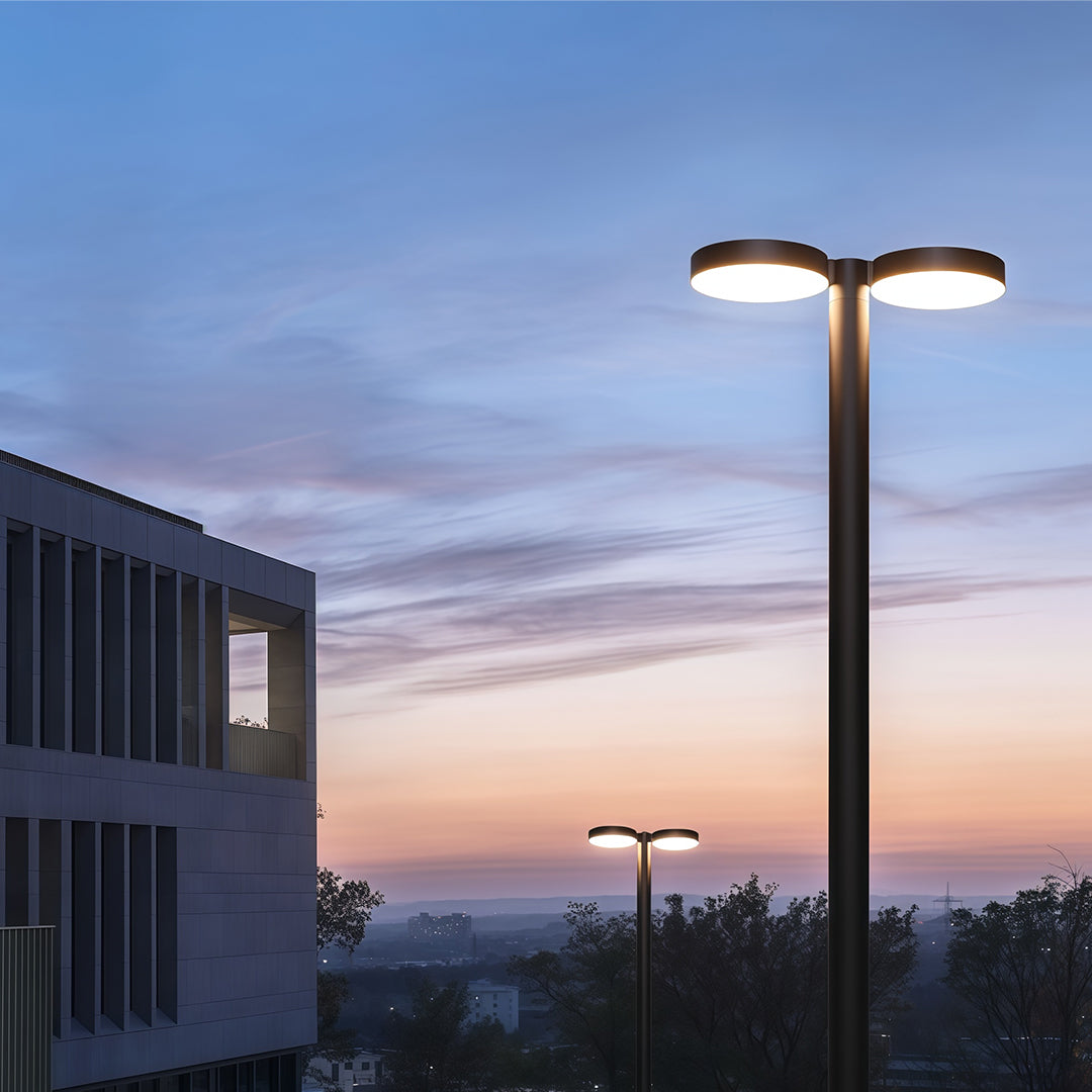 Evening shot of a modern outdoor street light glowing on a peaceful urban street.