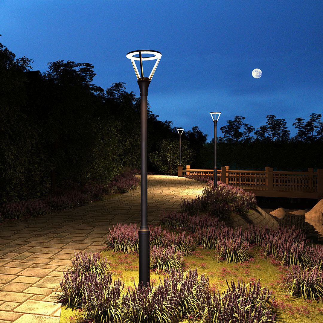 Evening park lighting with decorative fixtures illuminating landscaped garden areas at blue hour