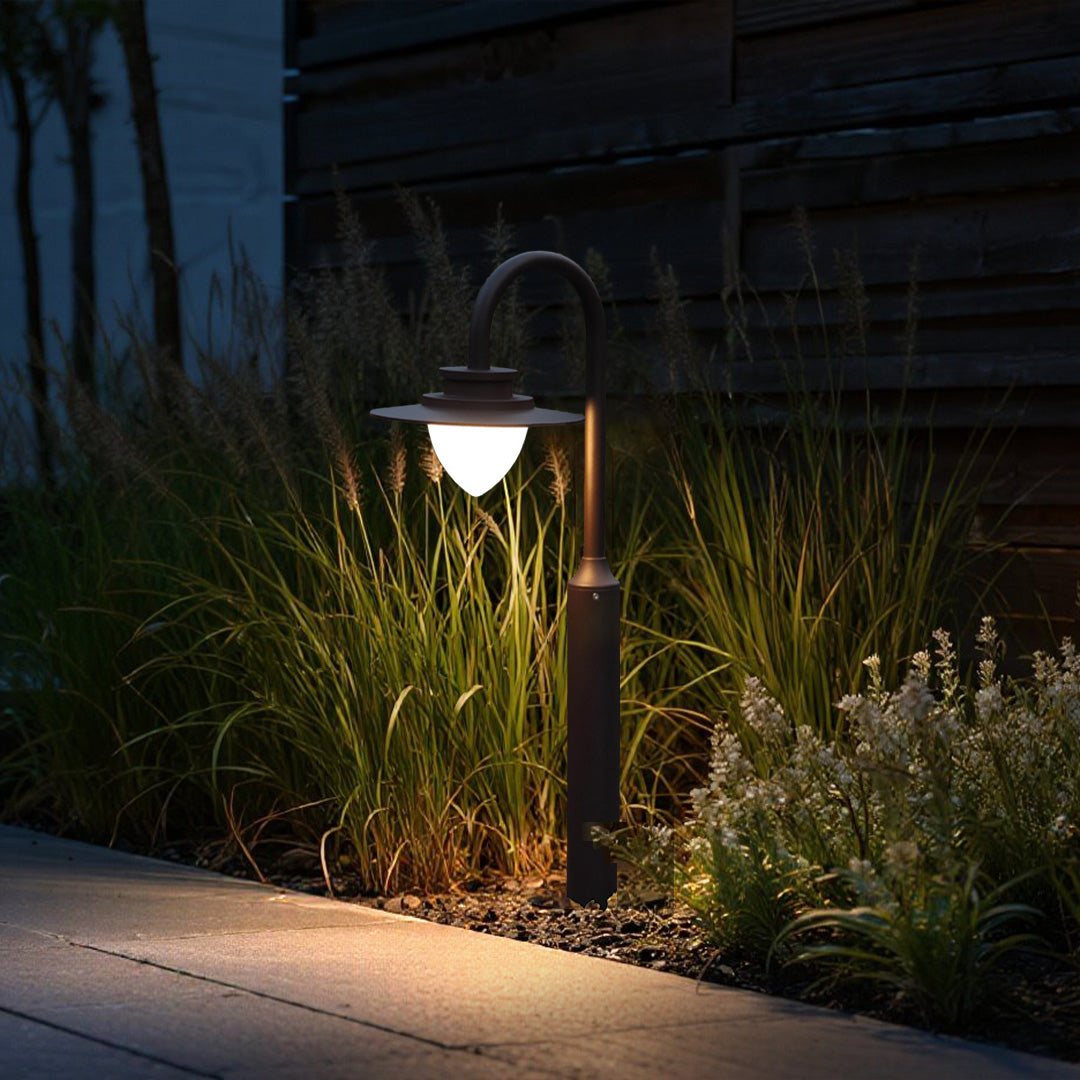 Evening garden lighting featuring shepherd's hook fixtures illuminating ornamental grasses and pathway