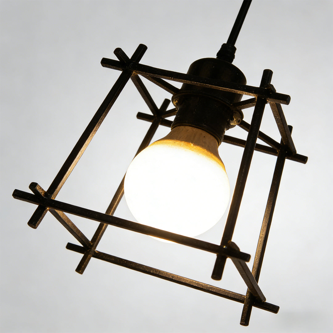 Detailed close up of exposed bulb inside an industrial style cage pendant light.