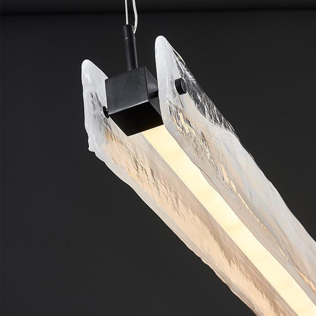 Glass pendant light for kitchen with exposed wood grain creating warm ambient lighting effect
