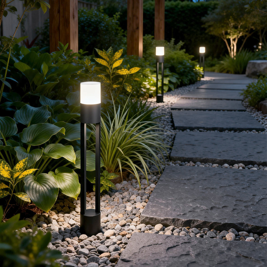 Exterior bollard light fixtures illuminating a modern garden pathway with warm directional glow.