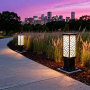 Exterior bollard lights lining a sidewalk at sunset, creating a warm and atmospheric outdoor lighting scene.