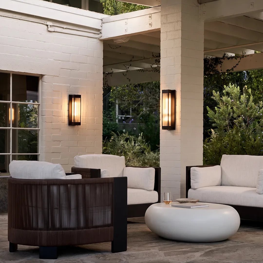 Exterior LED wall sconce lighting installed on a covered patio with white brick columns and outdoor seating.
