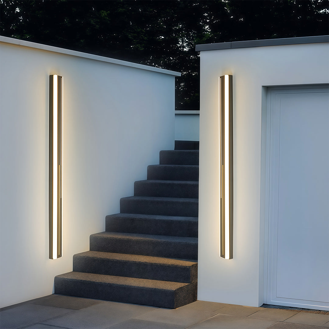 Outdoor wall mount lighting fixtures on contemporary building exterior creating dramatic evening ambiance