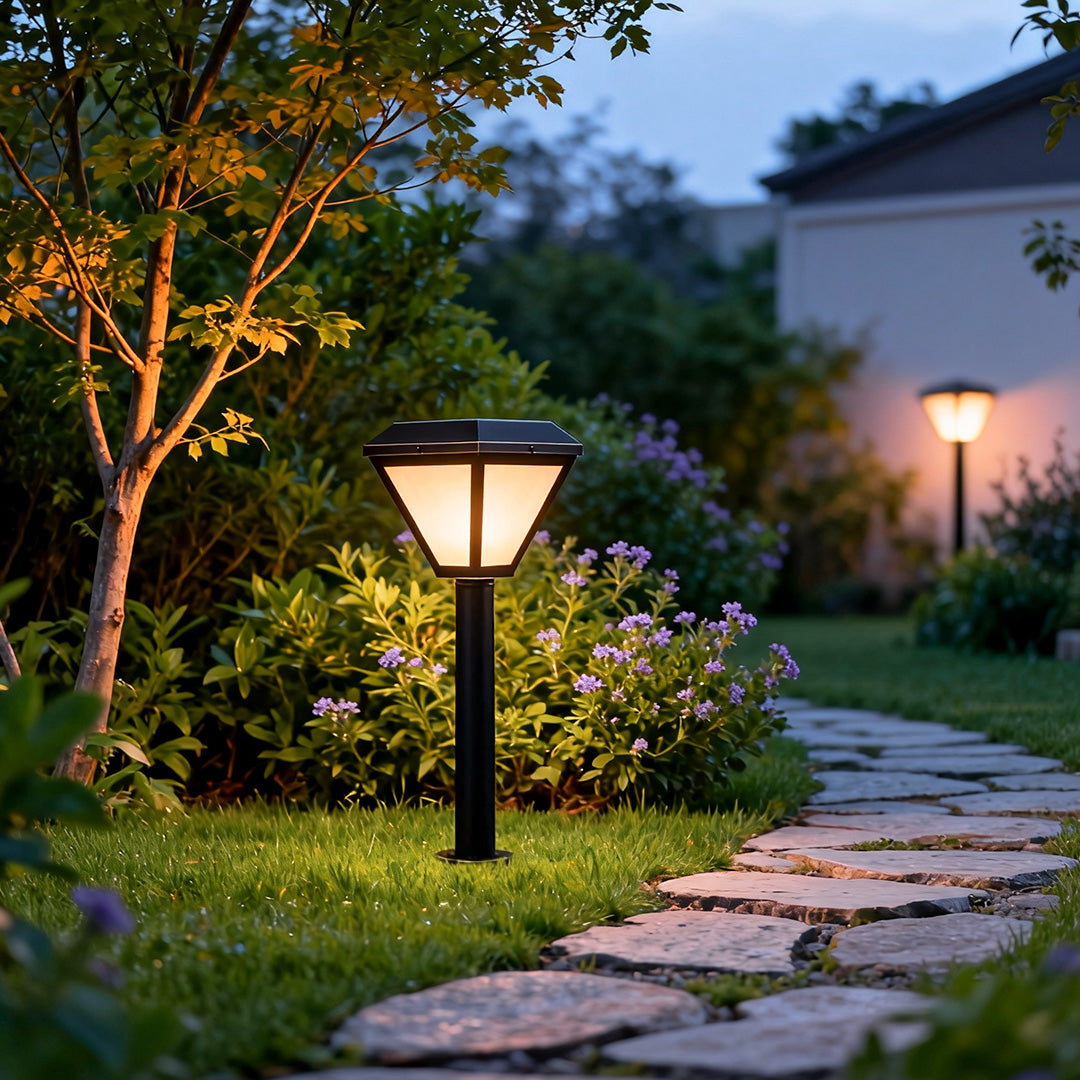 Exterior path lighting illuminating a cozy stone pathway in a garden during twilight hours.