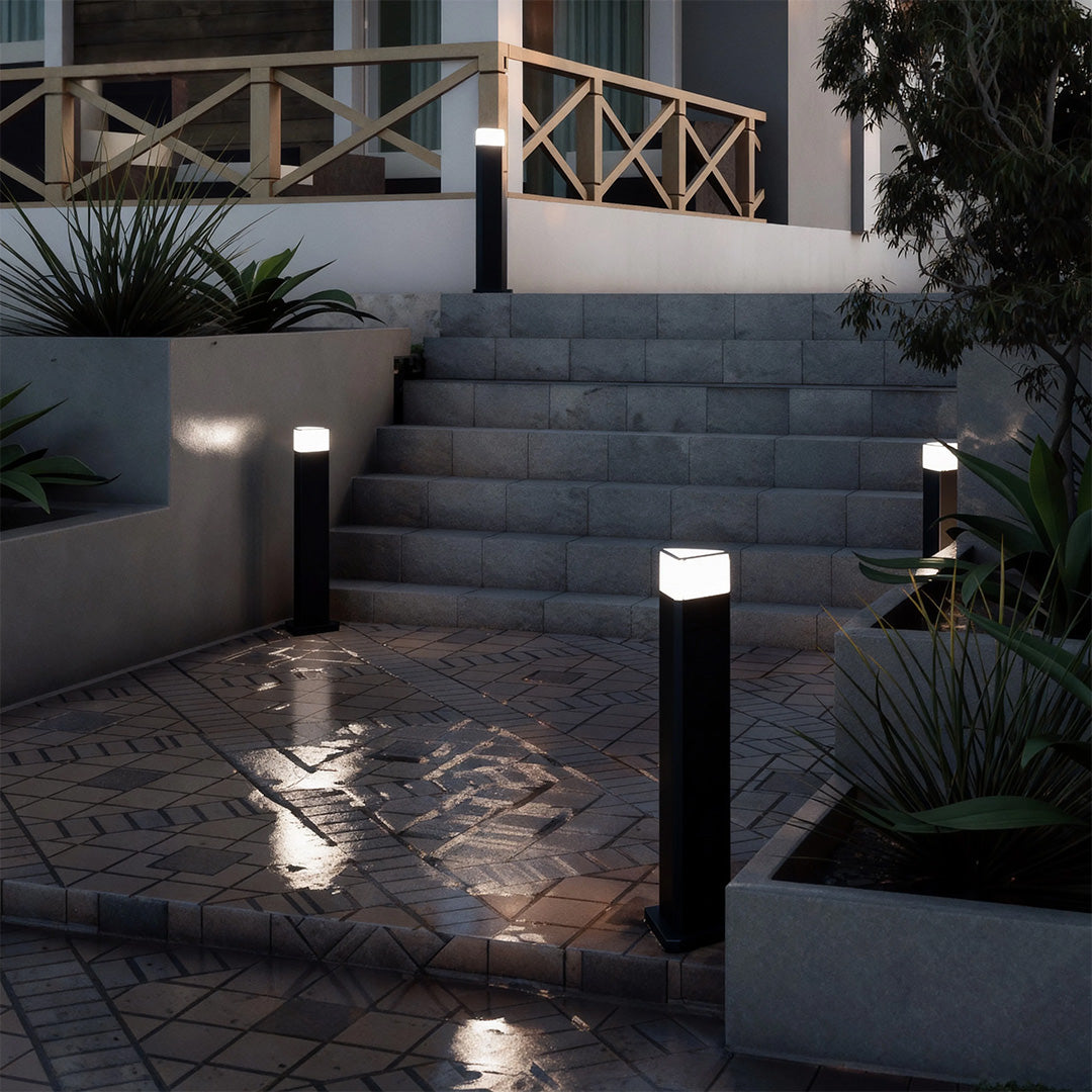 Exterior pathway light in a garden with plants, adding a contemporary touch to the outdoor space.