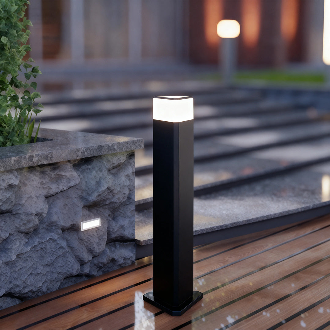 Exterior pathway light along a paved walkway, offering stylish and functional lighting.
