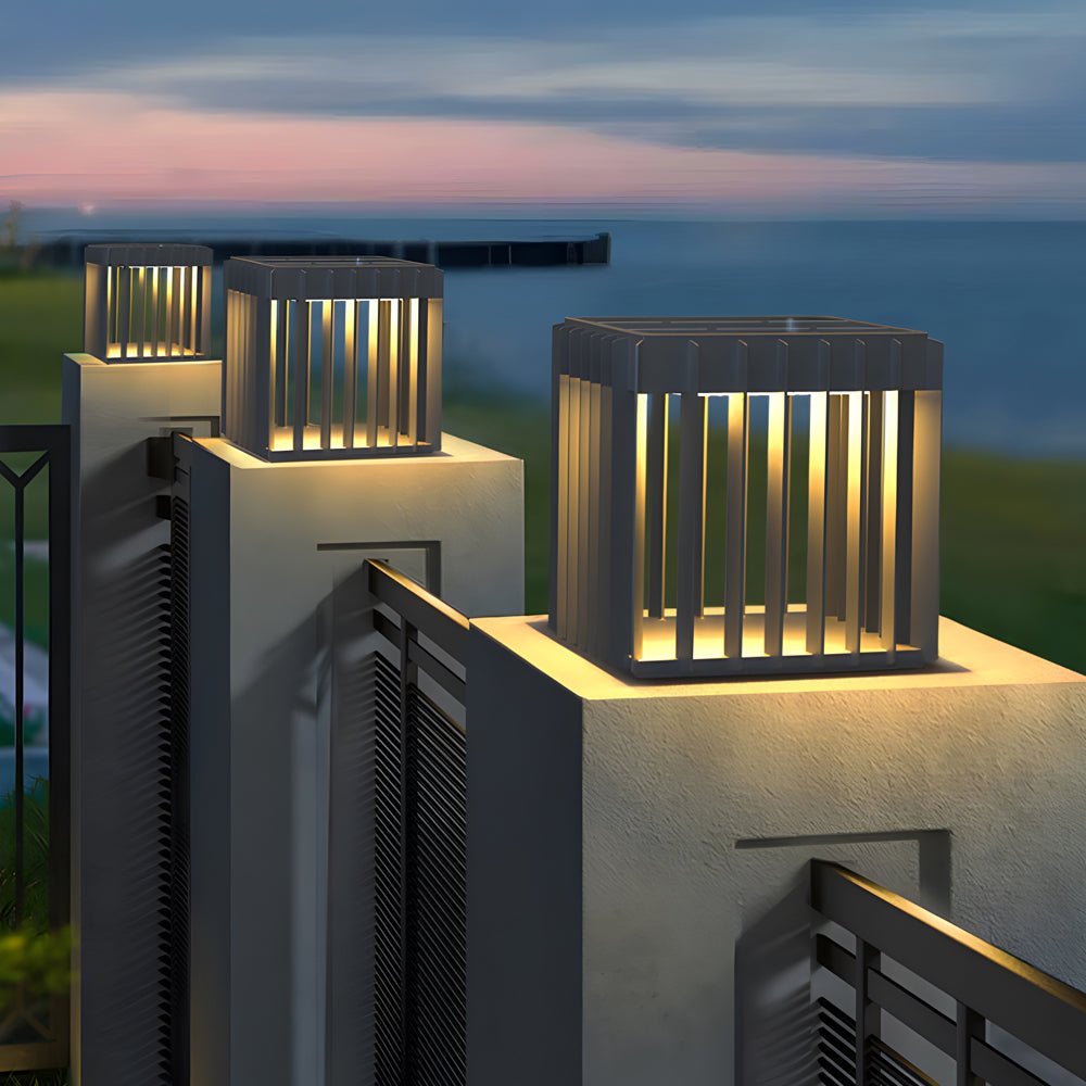 Exterior pillar lights providing soft illumination along a modern driveway with ocean view.
