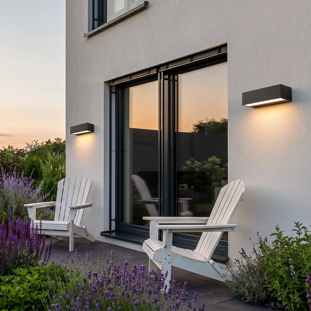Exterior porch light fixtures installed beside glass patio doors on a modern stucco home.
