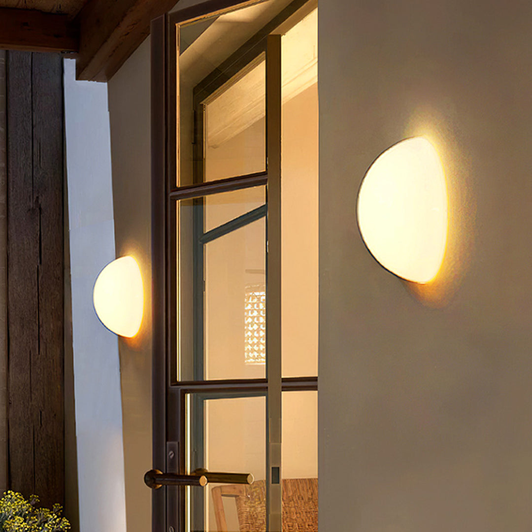 Elegant outdoor lighting wall mounted unit glowing on an exterior building wall.