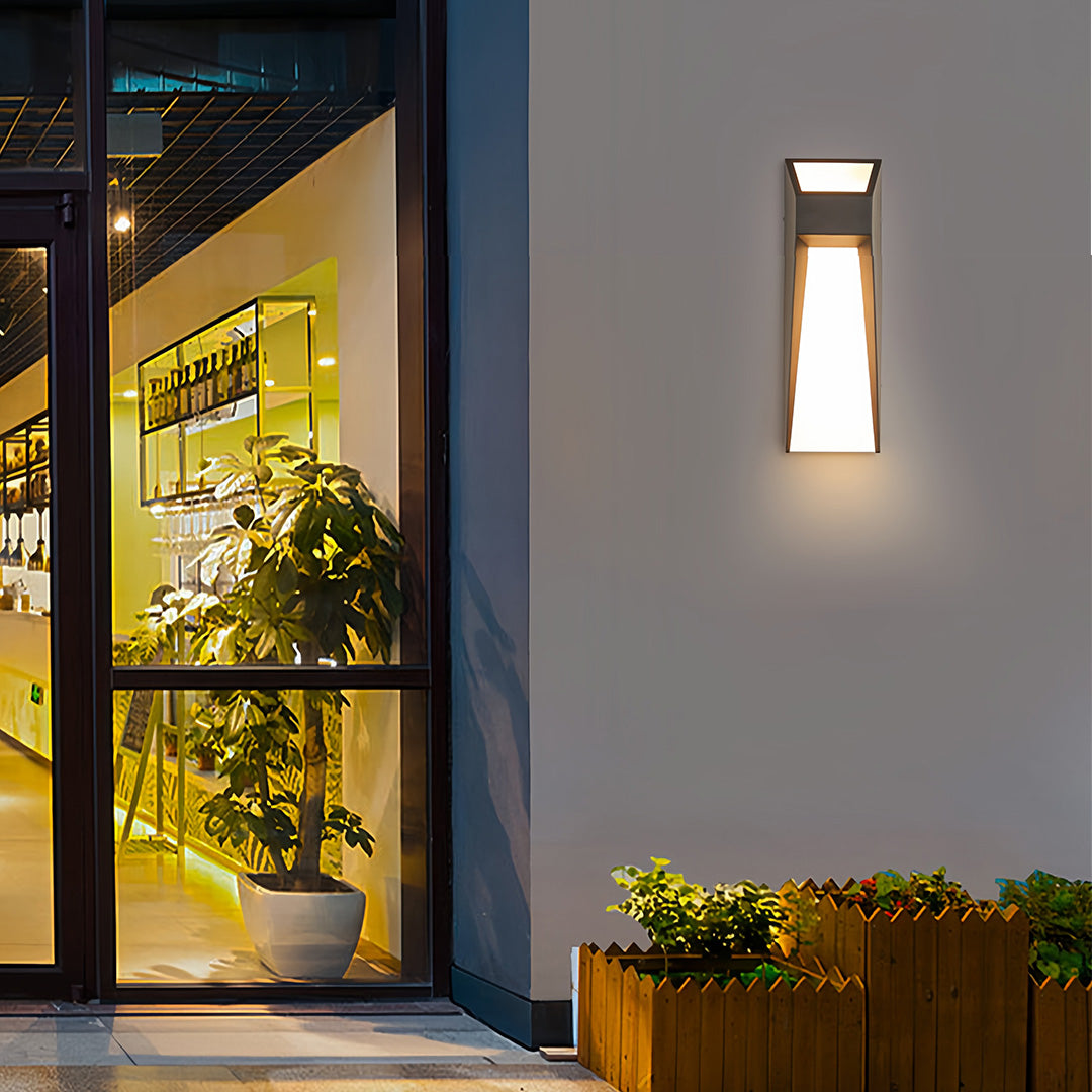 Extra large outdoor wall lights illuminating modern entryway with decorative plants and stone architectural elements