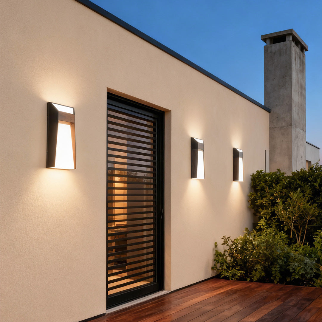 Extra large outdoor wall lights providing accent lighting on residential exterior with wood shutters and landscaping