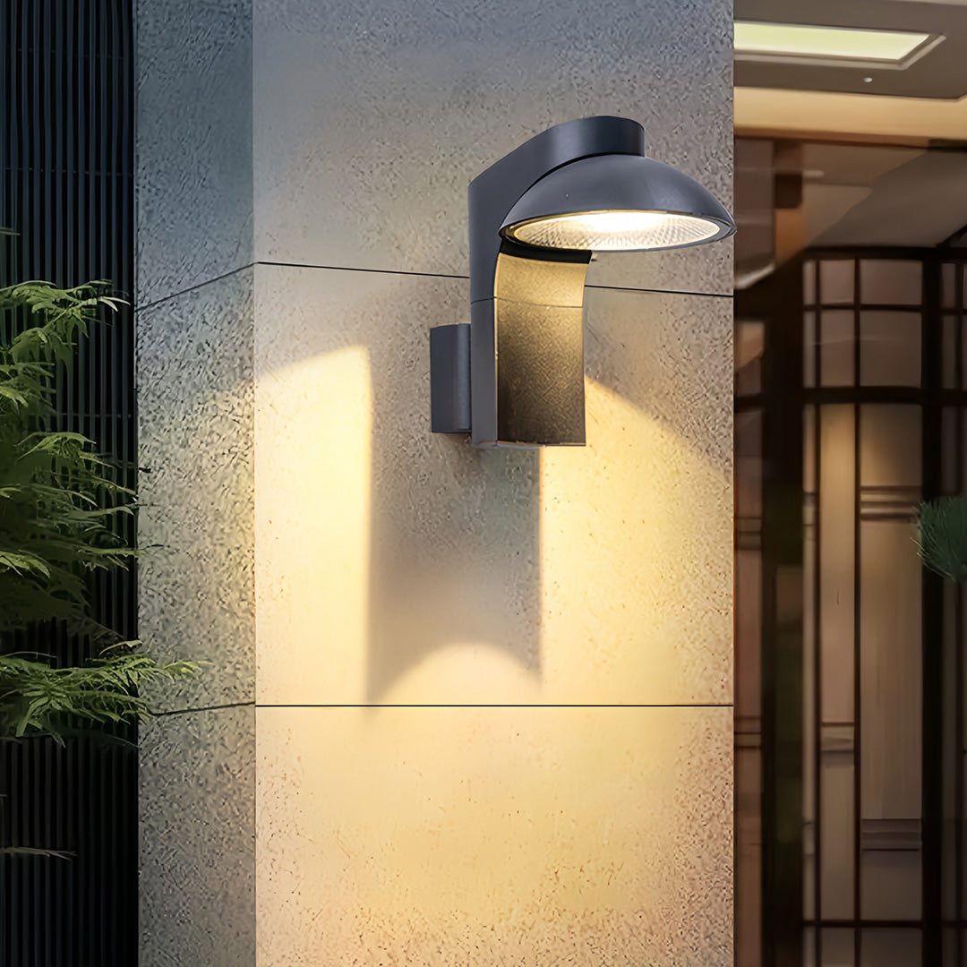 Extra large outdoor wall light mounted on stone façade creating wide downward illumination.