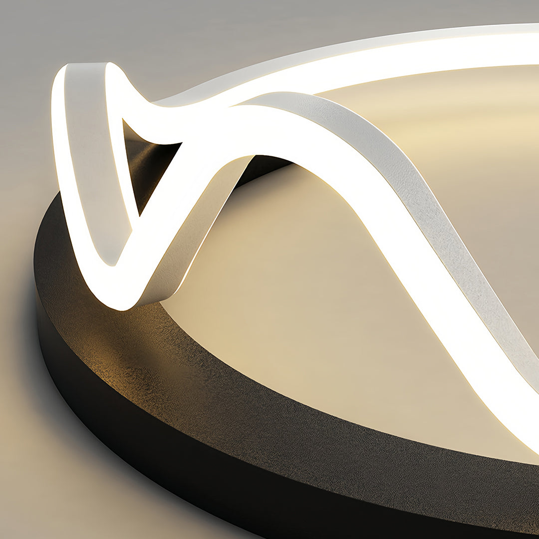 Extreme close-up of the geometric flush mount light, showing the illuminated white curved LED strip against the textured black circular base.