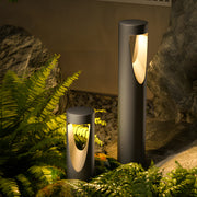 Garden landscape lighting featuring cylindrical bollards illuminating tropical plants and stone pathway