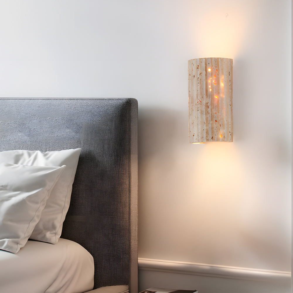 Luxurious bedroom setting with natural stone wall sconce creating intimate bedside illumination