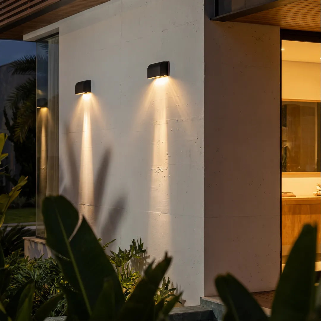 Facade spot lights mounted on a modern exterior wall, creating focused downward light beams.