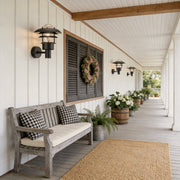 Farmhouse outdoor sconce with a rustic design, enhancing a white porch seating area.