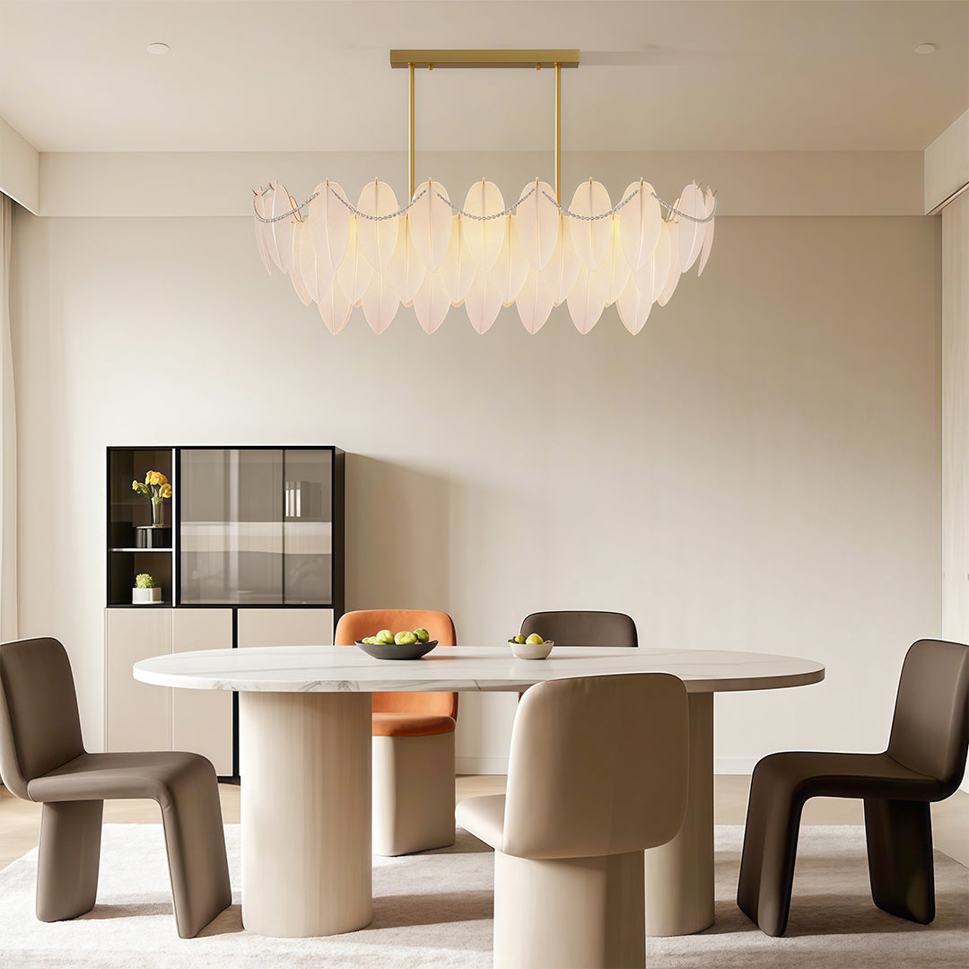 Modern luxury chandeliers illuminating bright kitchen dining area with white cabinetry