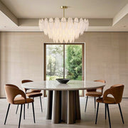 Feathers chandelier providing ambient light in contemporary workspace with minimalist desk