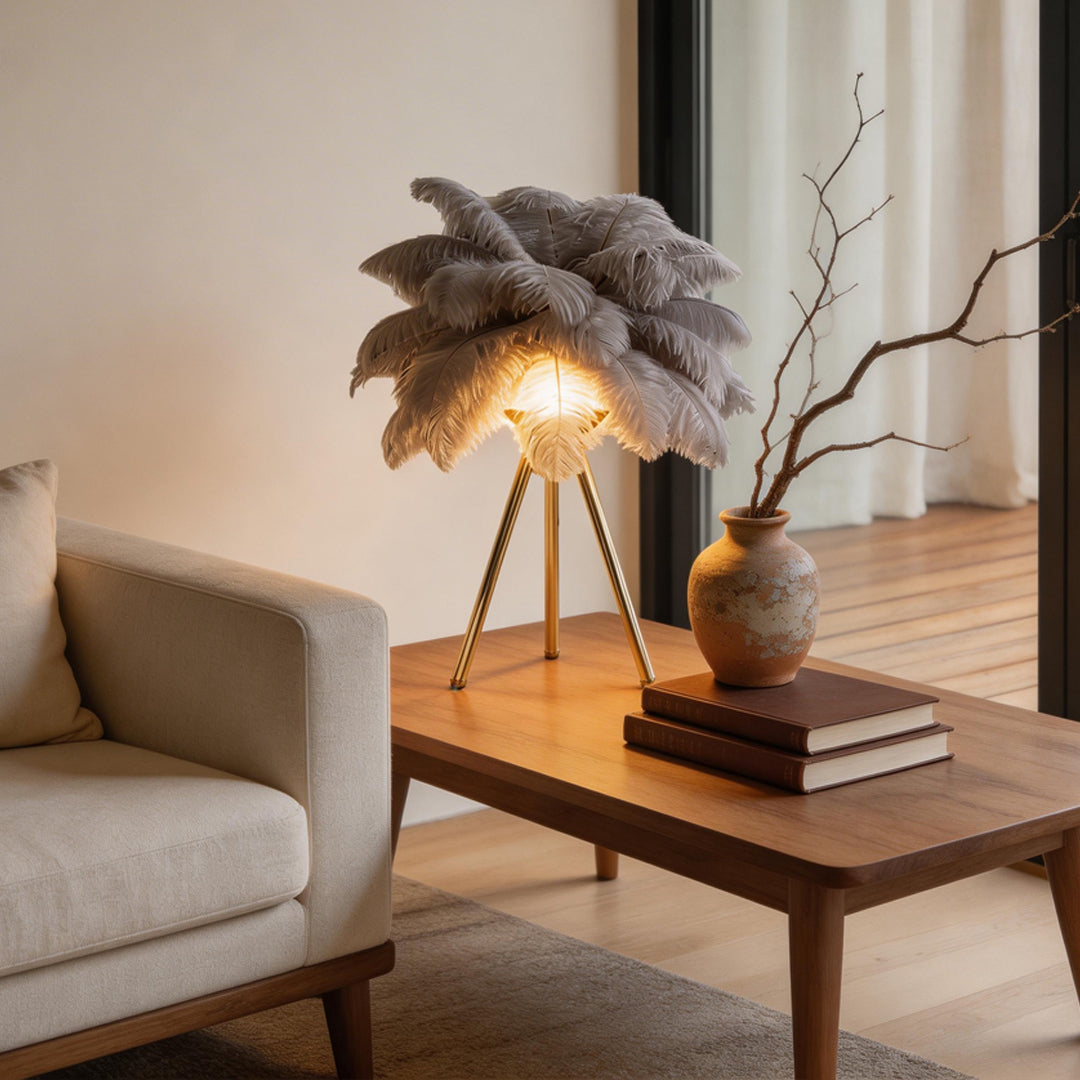 Feather table lamp with a grey feather design, illuminating a cozy living room.