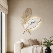 Feather wall clock with elegant golden design mounted in a modern living room.