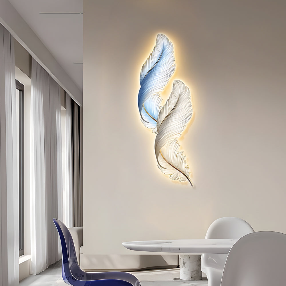 Artistic feather wall decor light positioned near a dining table, adding refined decorative lighting to the space.