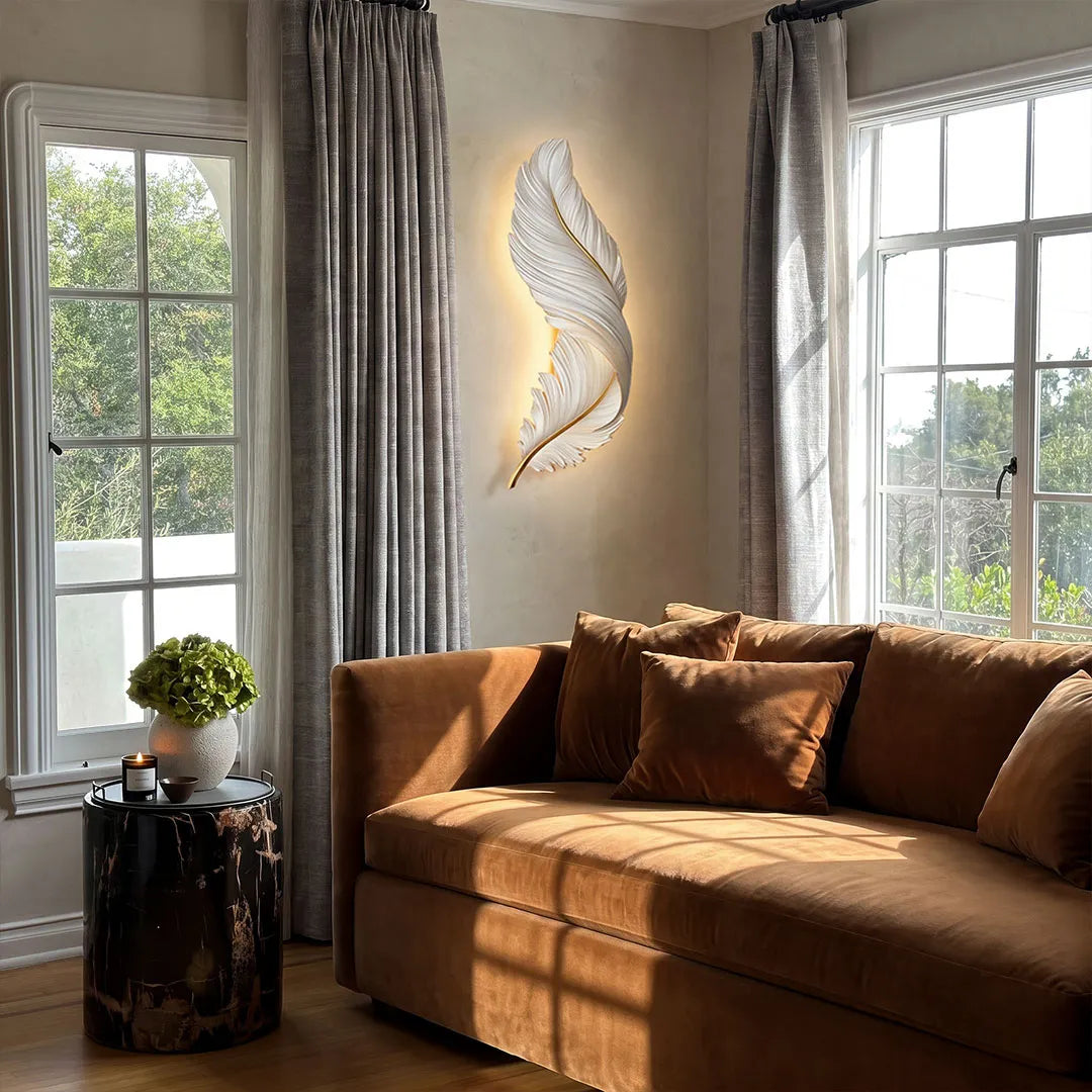 Feather wall lamp beside tall windows in a cozy living room, creating soft decorative accent lighting.